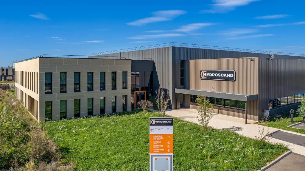 Construction-cle-en-main-CMC-pierre-taille-pathel-genas-vue-drone-proche-facade-Entourage-Communication Bâtiment industriel avec façade en pierre de taille naturelle issue de carrière pour le siège social de Pathel Hydroscand à Genas - Photo Entourage Communication - Julien Michel